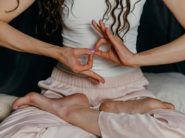 Close-up of a person's hands in a mudra gesture during breathing practice.